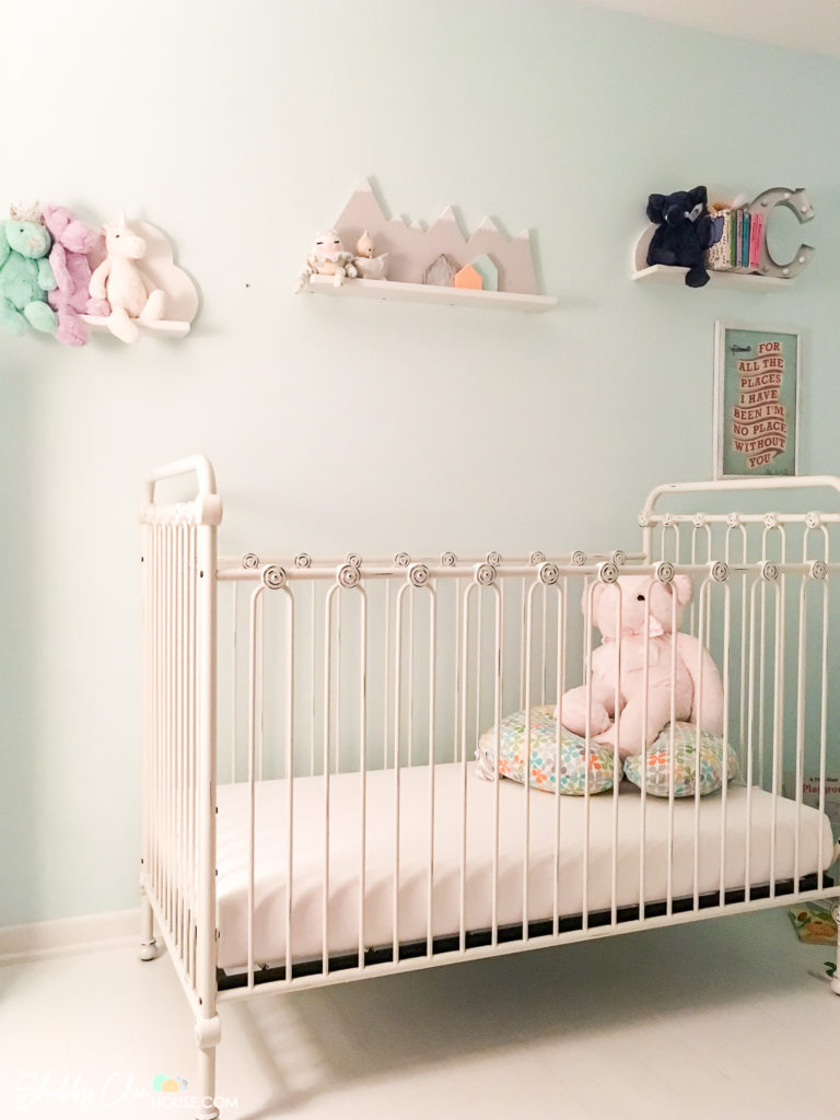 Gender Neutral Baby Room with white hardwood floor, white crib and mountain & cloud shelves