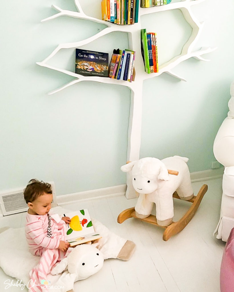 painted white hardwood floor, tree book shelf lamb play mat and lamb rocker