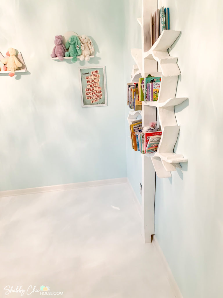 Tree shaped bookshelf cut near base to account for baseboards allowing the tree shelf to sit flush against wall