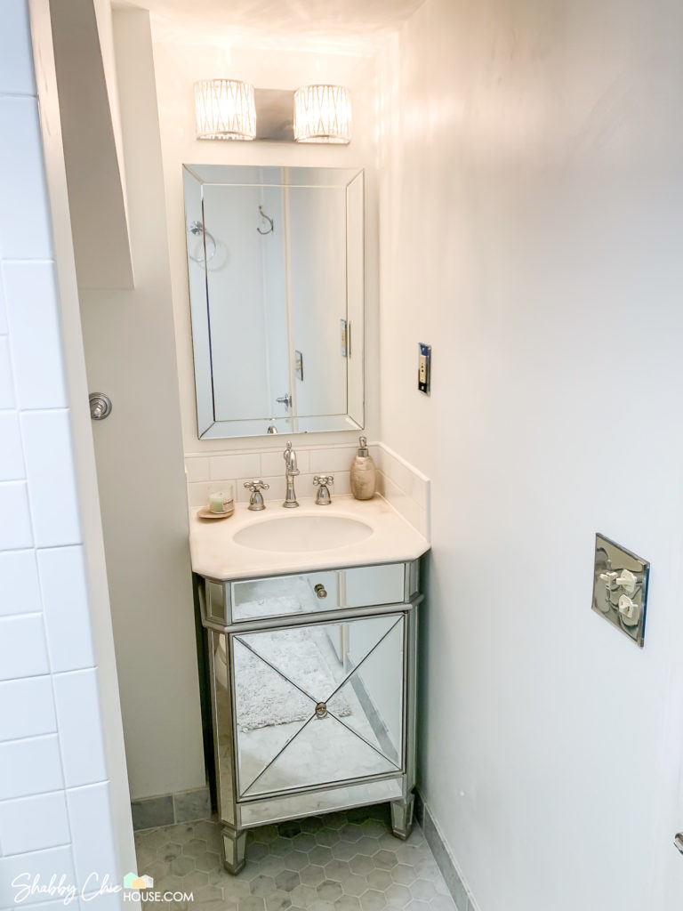 White Bathroom with white subway tile, Italian Carrara tile and mirrored vanity.