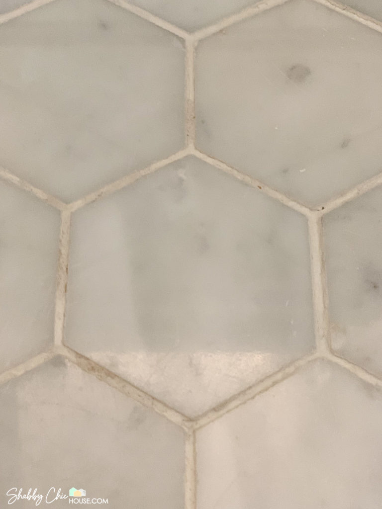 Close-up of hexagon tile and dirty white tile grout before refesh