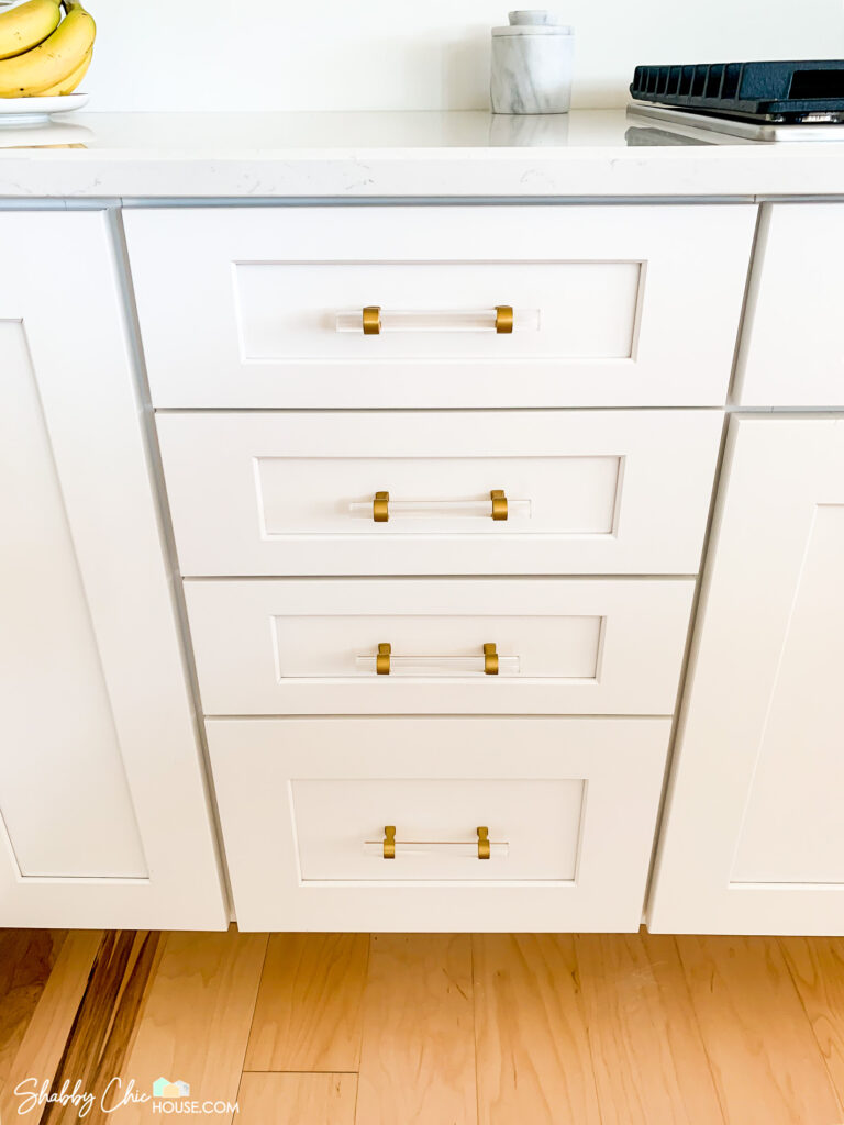 white shaker cabinets with gold and acrylic cabinet handles