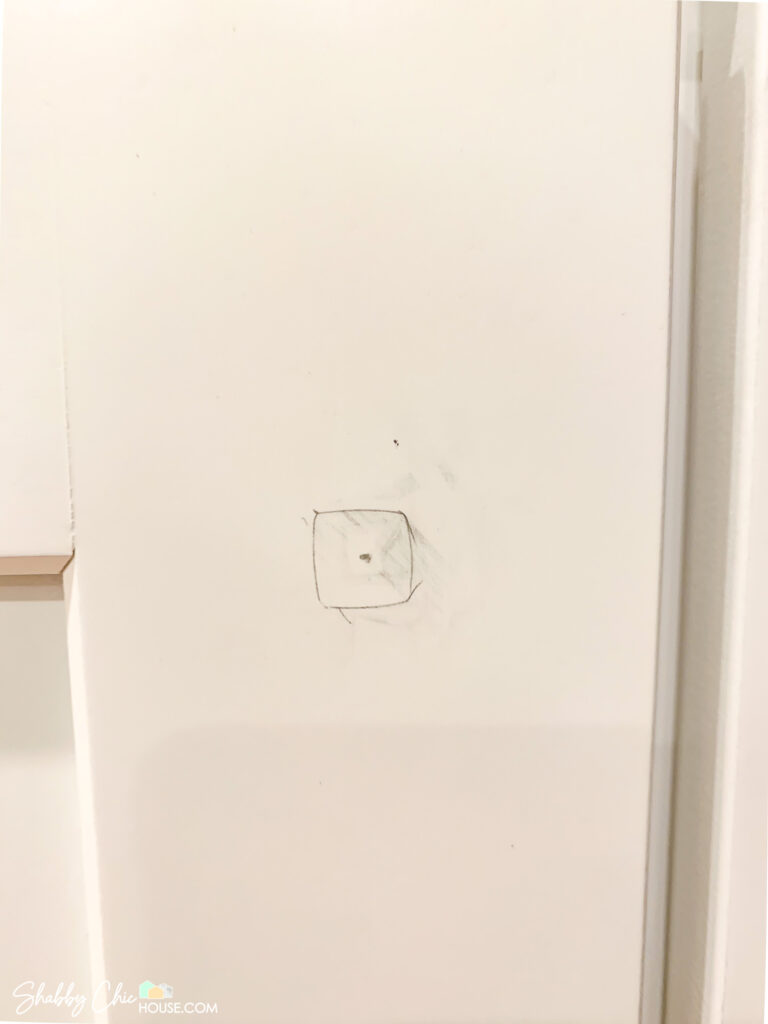 measuring and marking cabinet doors before drilling and installing cabinet hardware