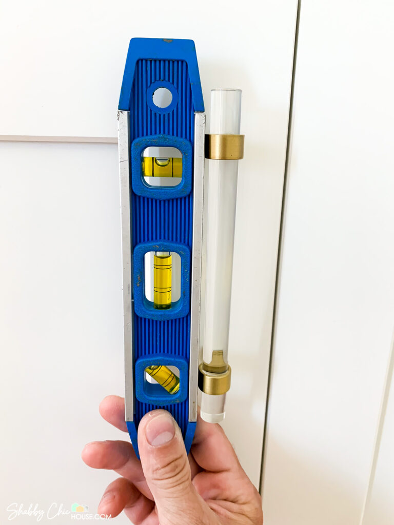 checking level prior to drilling and installing cabinet handles