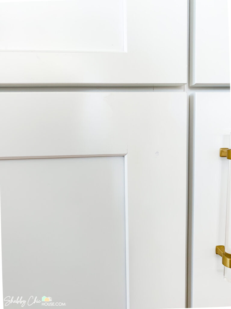 cabinet hole after wood filler and touch up paint