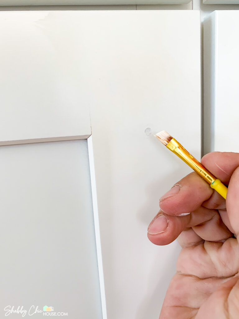 Using cabinet touch up paint to hide hole in cabinet