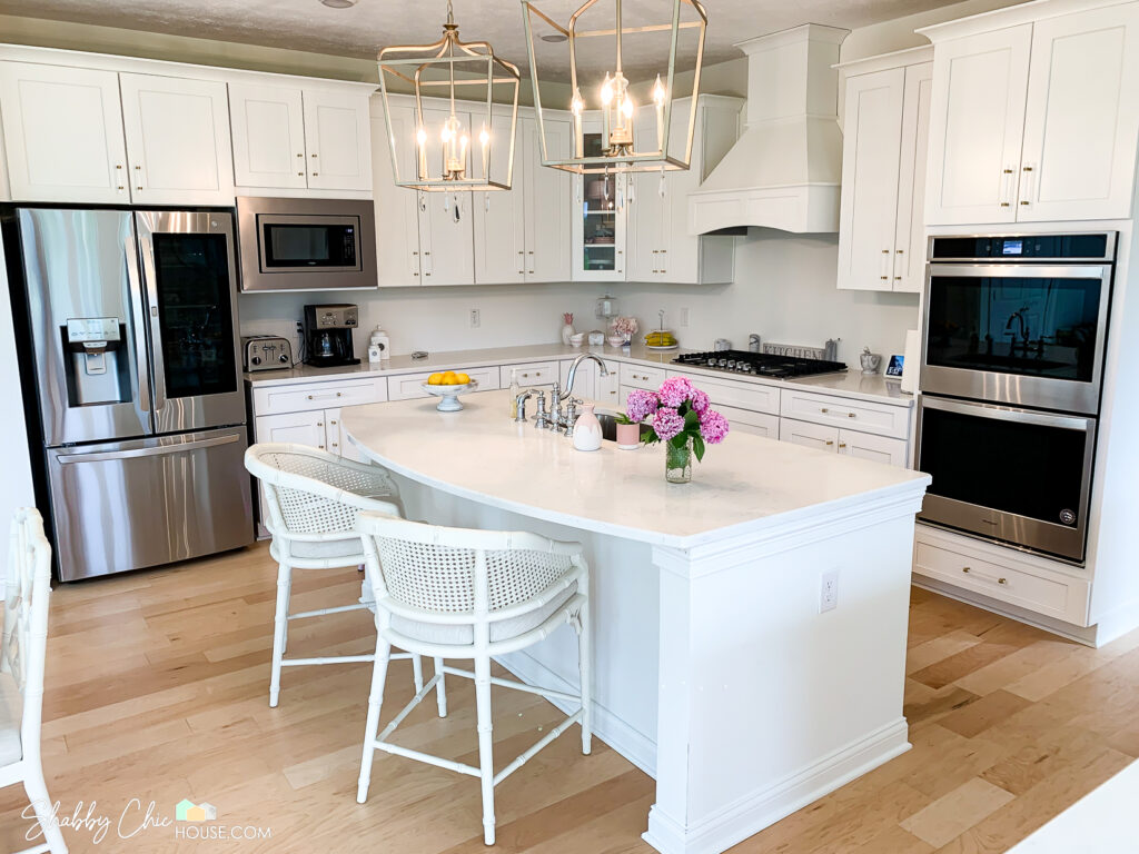 Kitchen with White Shaker Cabinets, Quartz Countertop Island, Minka Lavery Pendant lights, LG Fridge with craft ice