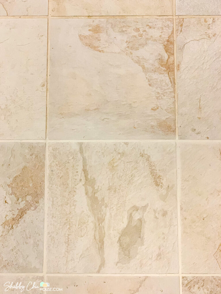 Image of two floor tiles from above. Top tile has gross and dirty grout. Bottom tile's grout has been cleaned and refreshed.