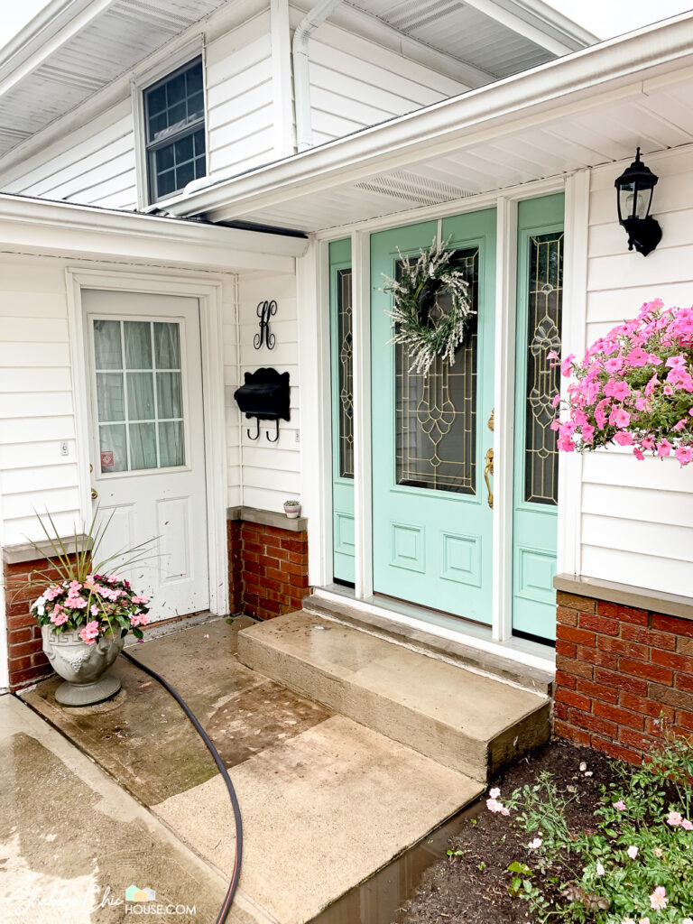 front of a house with half of the cement stoop power washed showing the before and after.