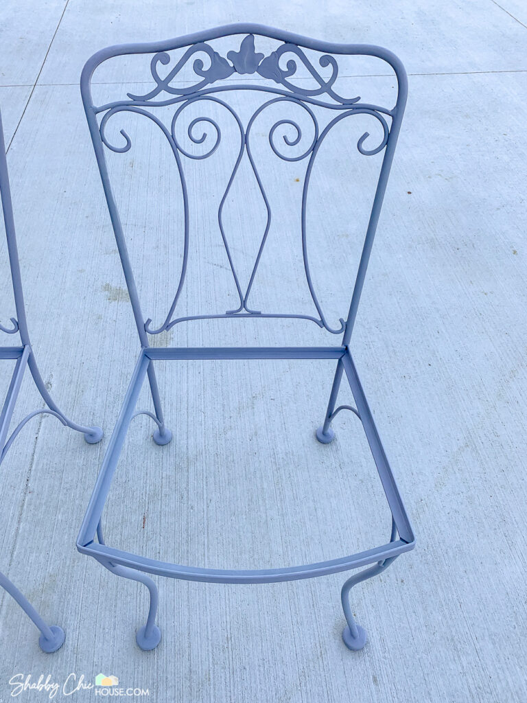 Single wrought iron chair that has been primed before repainted.