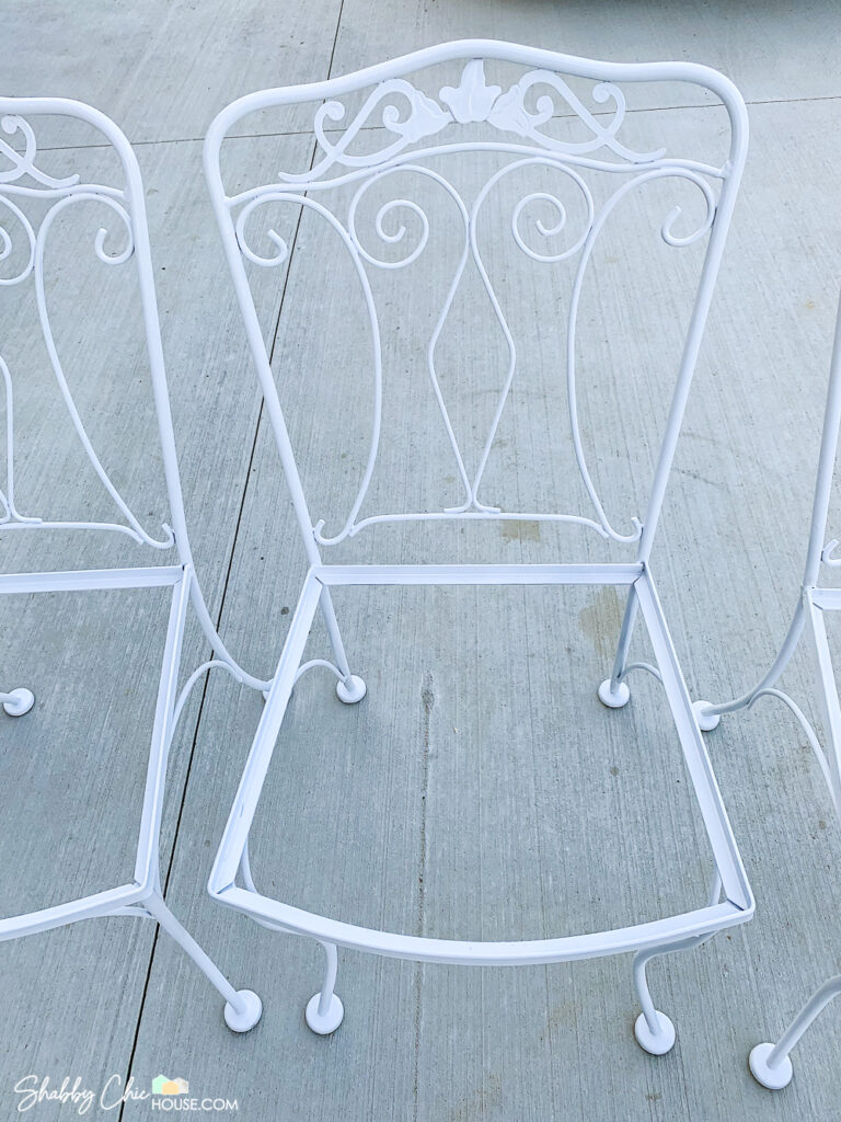 Wrought iron patio set chair right after being restored and repainted white.