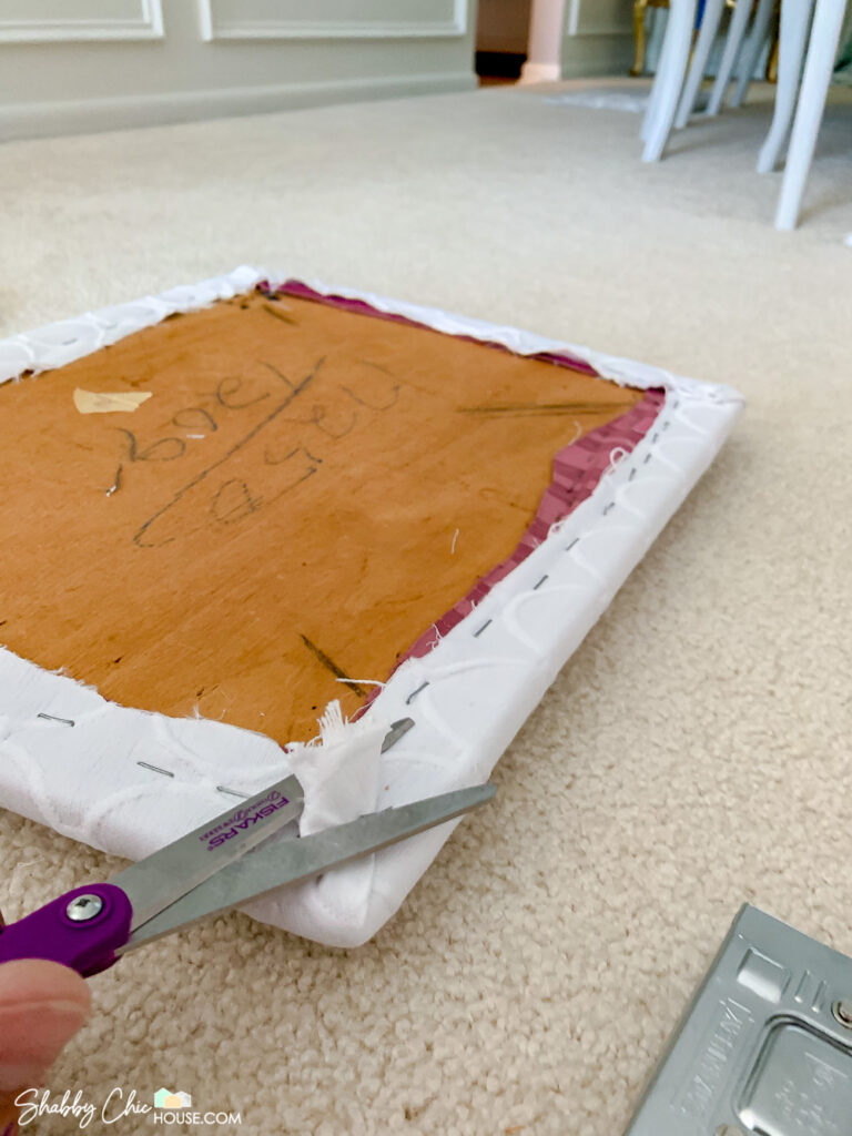 reupholstering a seat cushion and after stapling trimming the excess fabric