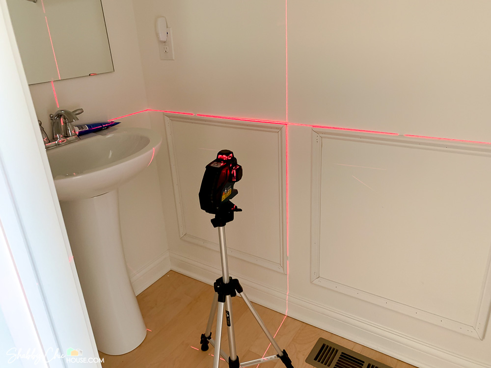 Bosch laser level being used to install wainscoting.
