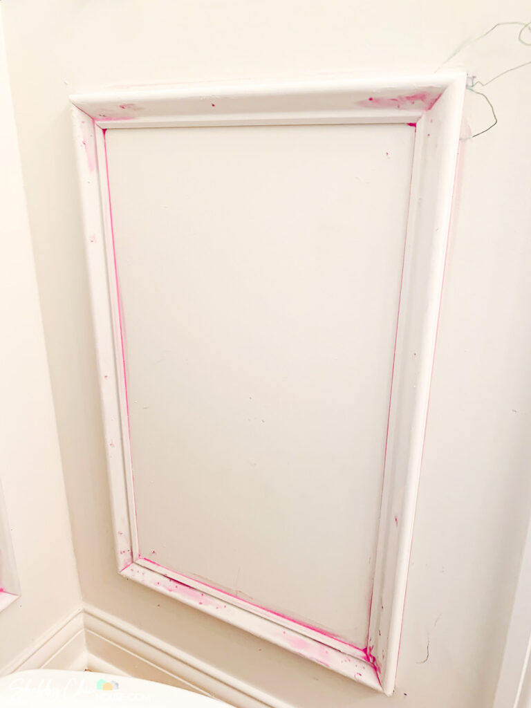 Using DAP's DryDex which goes on pink and turns white when dry to fill the holes and gaps on a wainscoting box.