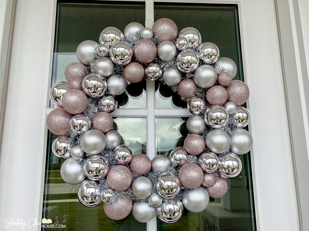 Close-up on a pink and silver Christmas ornament wreath for a blog post on top 2022 holiday decor.