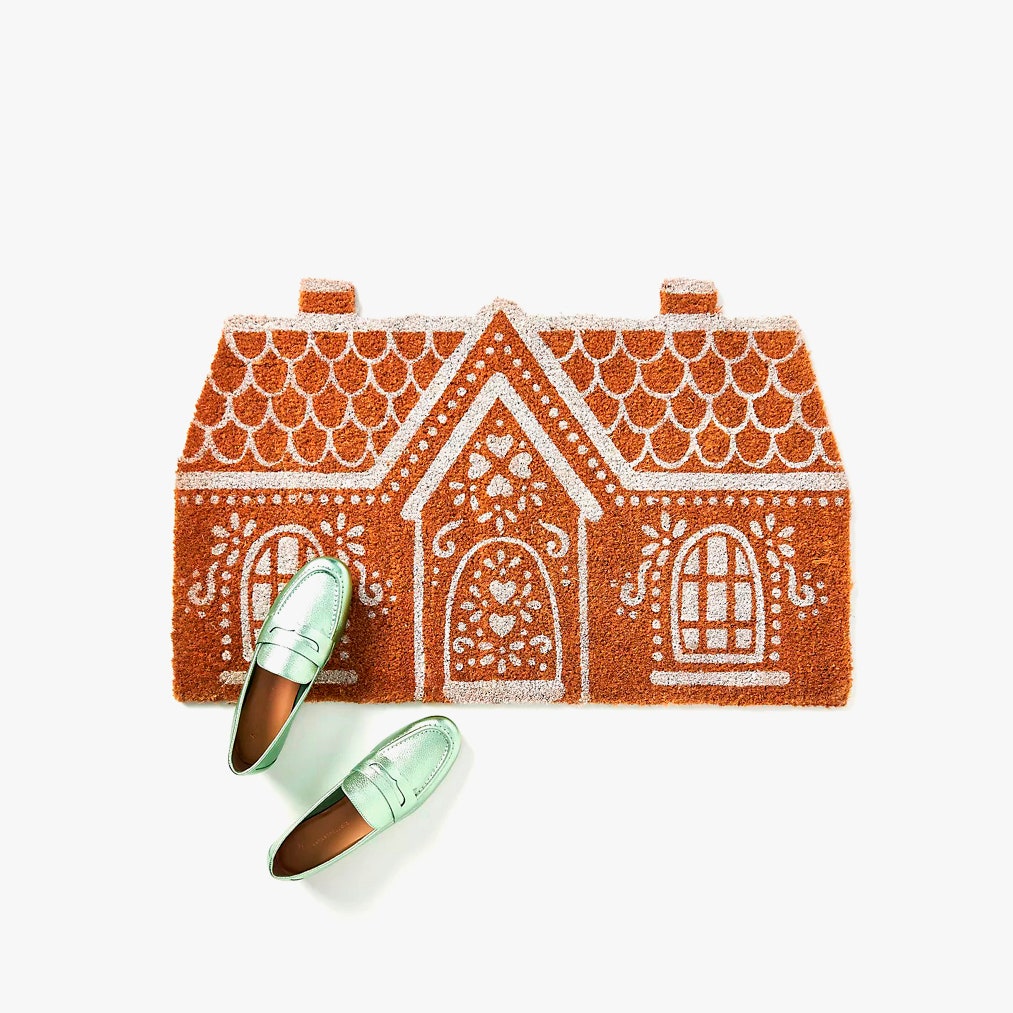 Image of a door mat that is shaped like a gingerbread house from Anthropolgie for a blog post on the top Christmas decoration ideas for 2021.