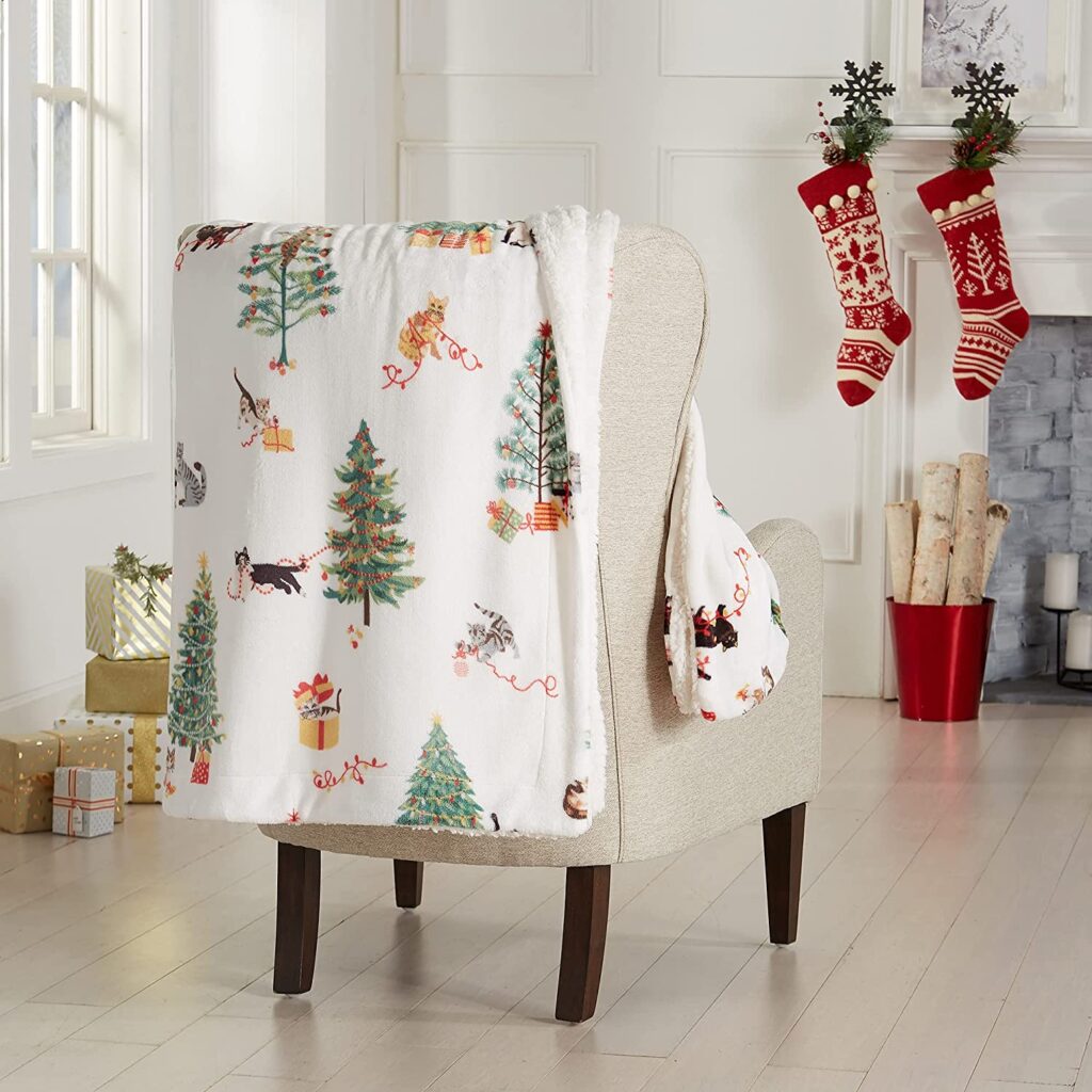 Image of a cat themed throw blanket draped over a chair for a blog post on 2022 holiday decor.