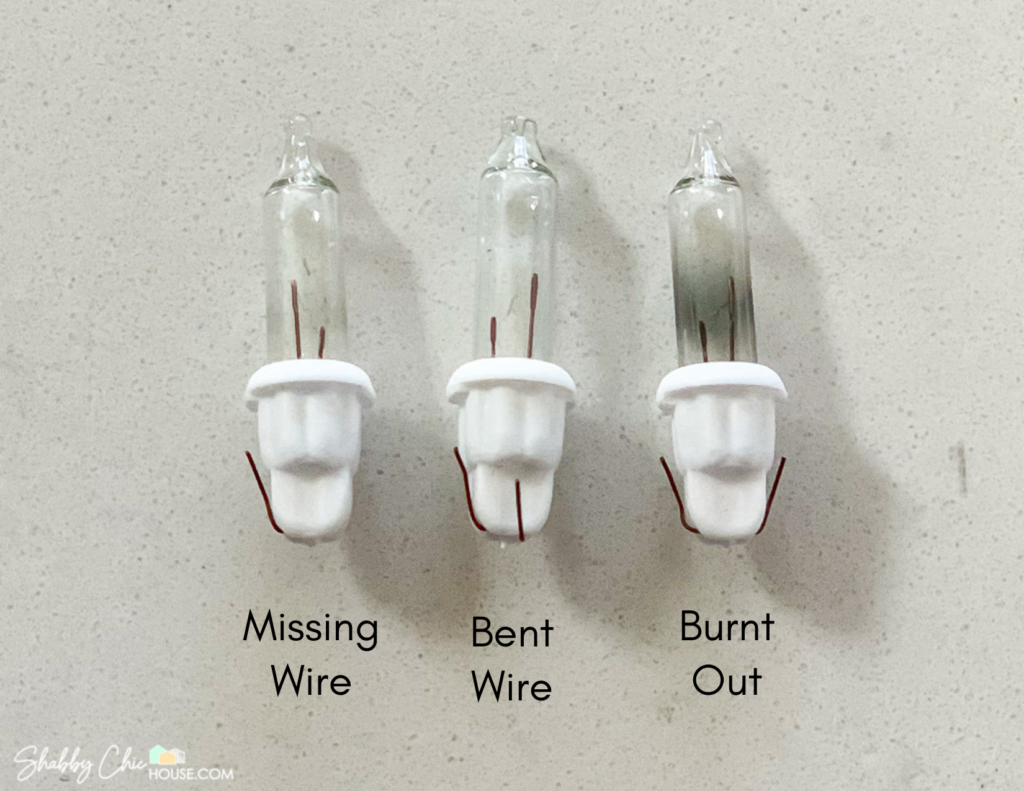 Photograph of three malfunctioning Christmas light bulbs for a blog post on how to fix broken Christmas tree lights. The first bulb has broken leads. The second has a bent lead. The third bulb has been burnt out.