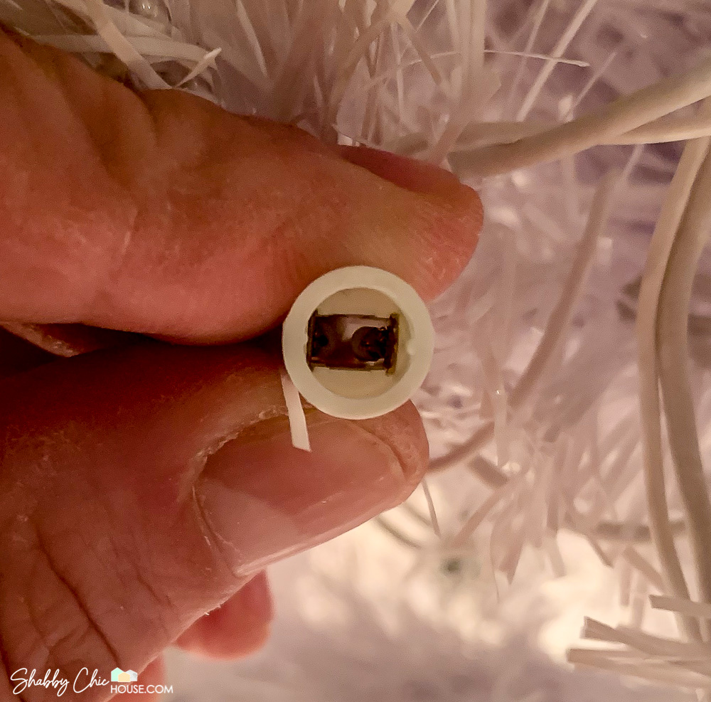 Close-up shot of inside of a working Christmas tree light bulb socket.