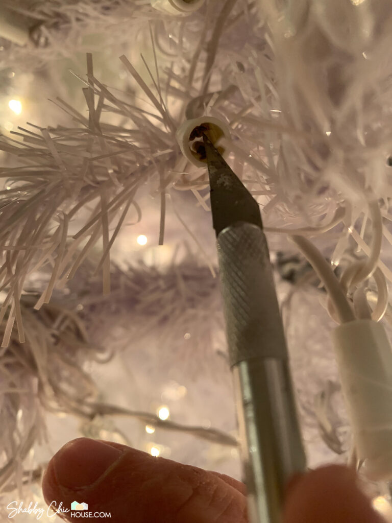 Image showing how to reseat the wiring and fix a Christmas tree's light bulb socket.