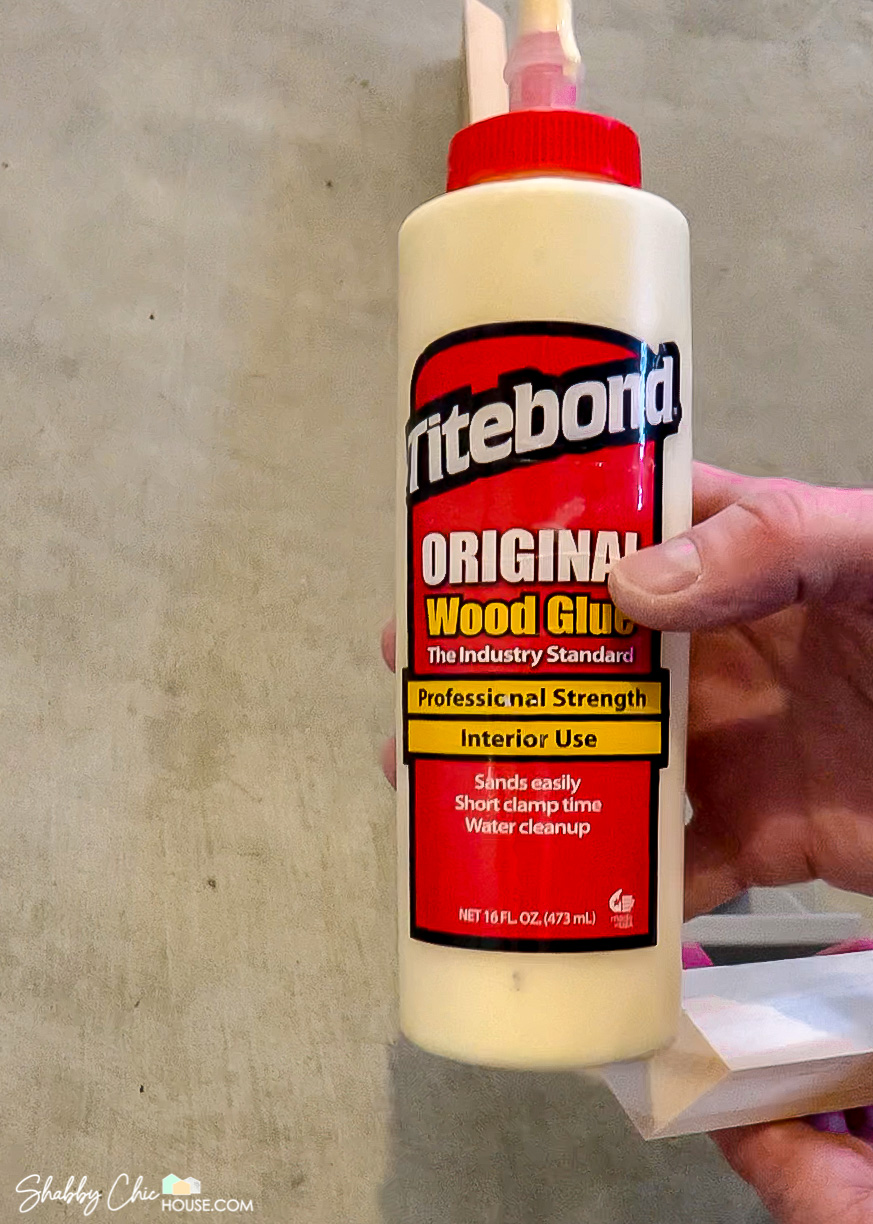 Close-up of a bottle of Titlebond Original Wood Glue being used to glue together a wooden DIY floating picture frame.